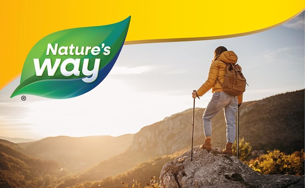 Hiker wearing yellow jacket looking over vast valley.