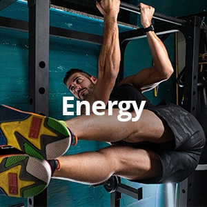 a man working out in a gym suspended in a pull up with the word energy